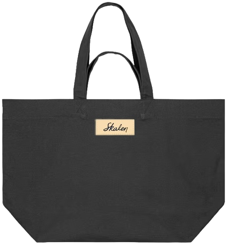 L'autre face du shopping bag marron, unie, avec au centre, sous les anses, une étiquette beige cousue, au logotype « Skalen » en marron.